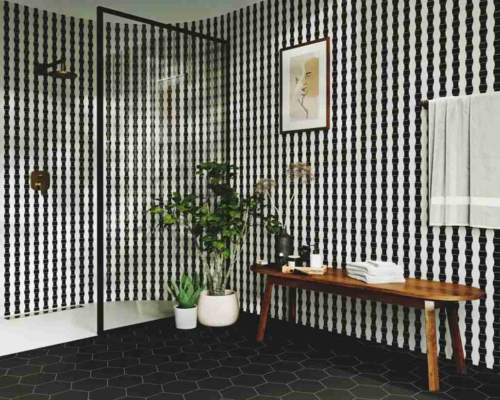 Stonowane, czarno-białe wnętrze, a do tego… odważna, graficzna wersja obrazu na ścianie to sposób na efektowny detal w modernistycznym stylu. Aranżacja cbiało czarnej łazienki - modernizm.